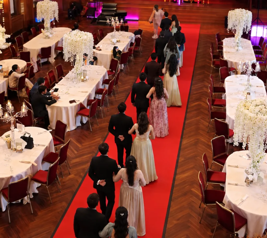 Guests walking a red-carpet aisle at a reception