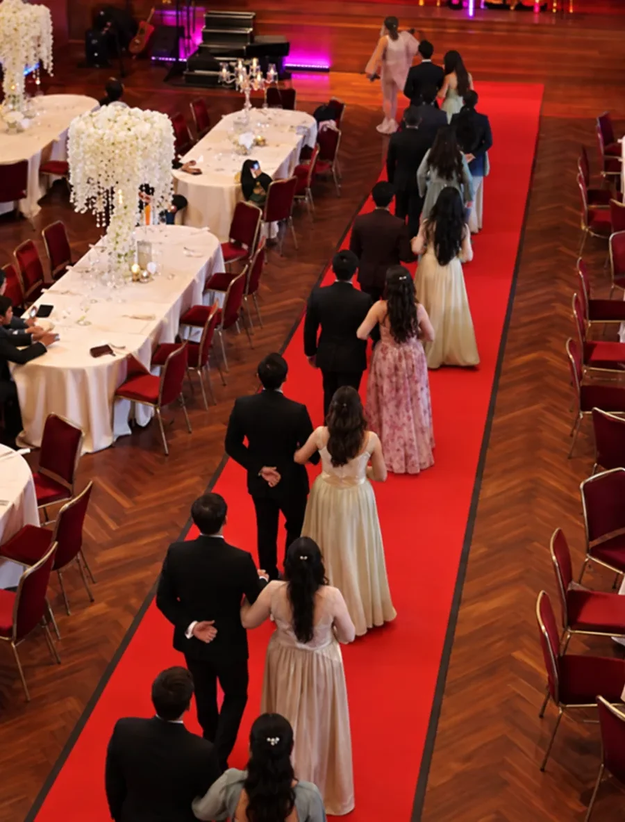 Guests walking a red-carpet aisle at a reception