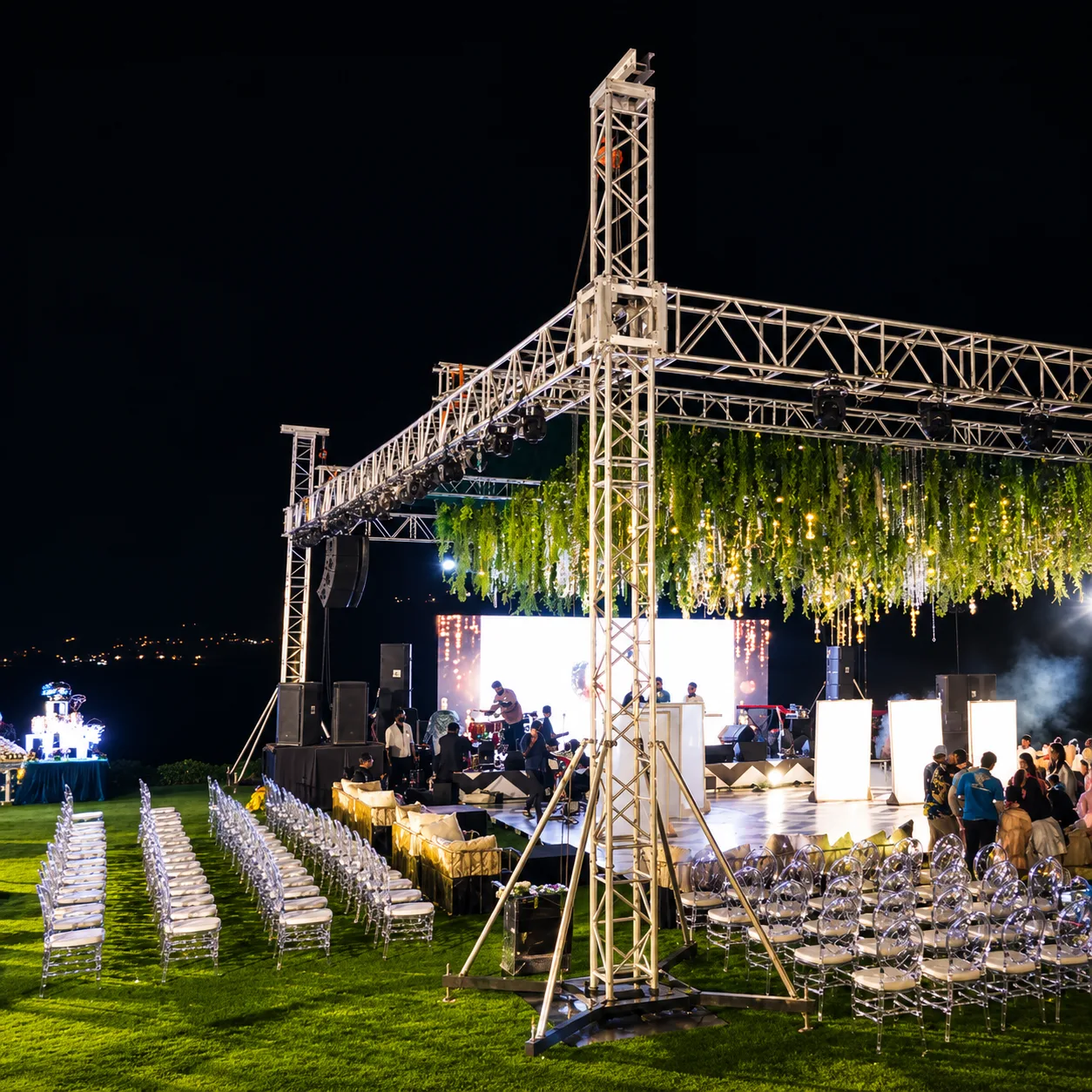 Evening social event with a lit stage and seating