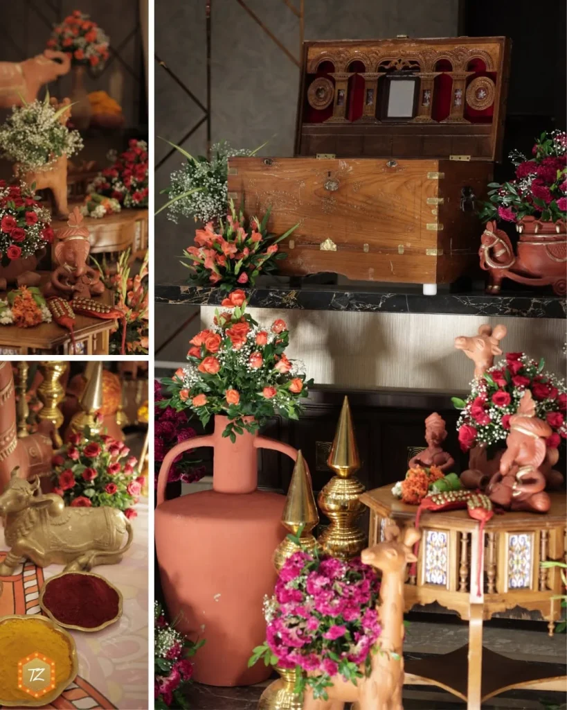 Traditional wedding decor with terracotta figures, brass accents, flowers and a carved wooden chest